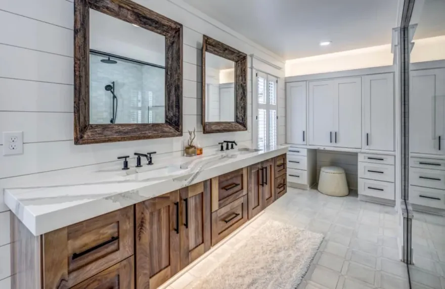 Primary bathroom remodel with a double walnut vanity, white quartz waterfall countertop, black fixtures and rustic wood-framed mirrors