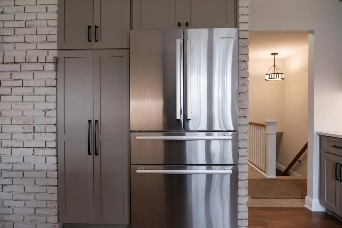 Detail of the refrigerator framed by the original brick, reworked into the new kitchen layout